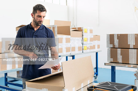 Warehouse worker scanning paperwork in distribution warehouse