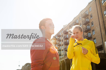 Runners standing by building block, Wapping, London