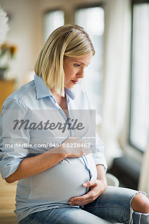 Full term pregnancy young woman sitting on table