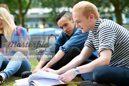 Male students sitting working on college campus