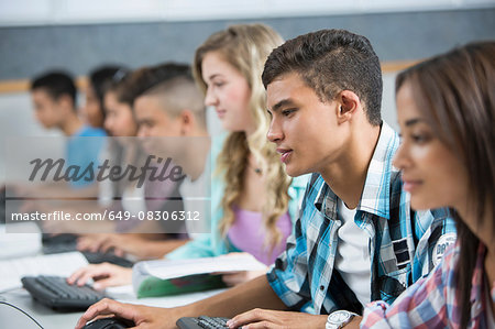 Row of teenage high school students using computers