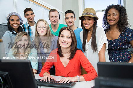Portrait of female teacher and high school students in computer class