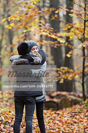 Girls hugging in autumn forest