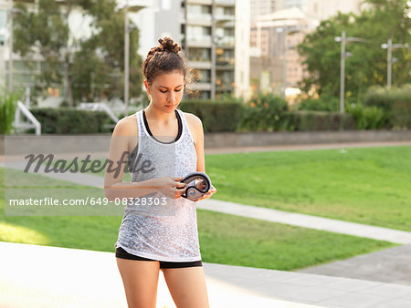 Young woman holding wrist weight in park