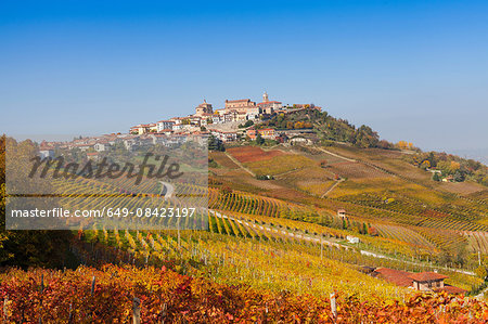 View of autumn vineyards and hill village, Langhe, Piedmont, Italy