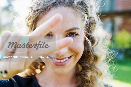 Young woman making peace sign with hand