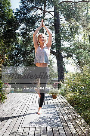 Young woman doing tree pose in garden