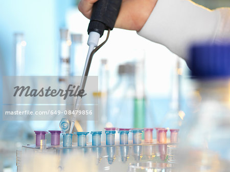 Scientist pipetting sample into eppendorf vial during experiment in laboratory