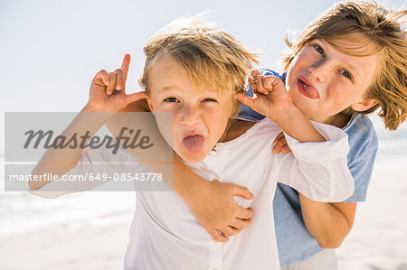 Brothers looking at camera, poking out tongue