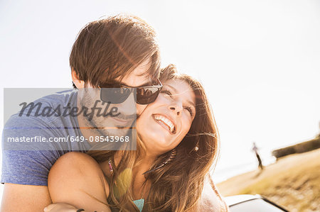 Mid adult couple hugging on coast road, Cape Town, South Africa