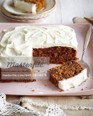 Carrot cake with frosted icing on pink dish