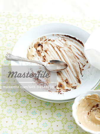 High angle view of plate and bowl with the remains of chocolate fondant and cream