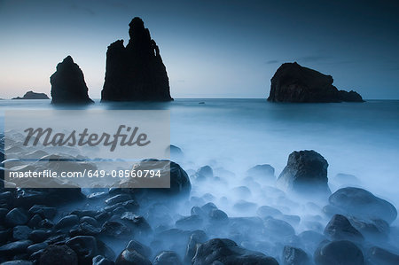 Foggy rock formations on beach