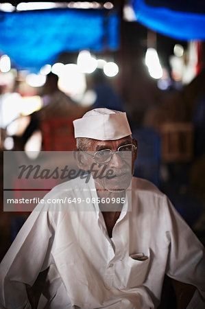 Older cook wearing paper hat outdoors