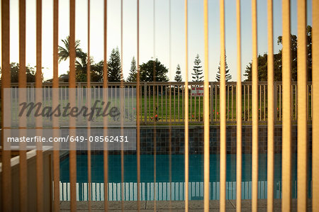 View of swimming pool through window blinds