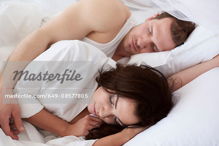 Young couple asleep in bed