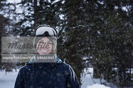 Portrait of young woman wearing ski goggles in snow, Brighton Ski Resort outside of Salt Lake City, Utah, USA