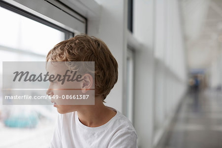 Boy looking out of airport window