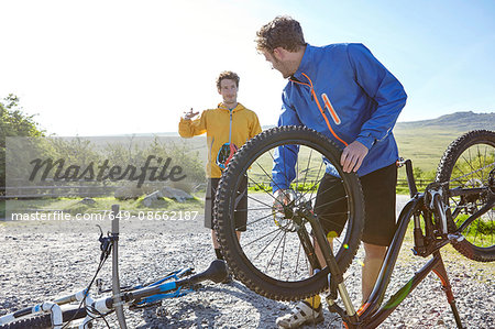 Cyclist attaching bicycle wheel to bicycle