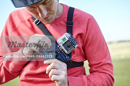 Man attaching action camera to chest