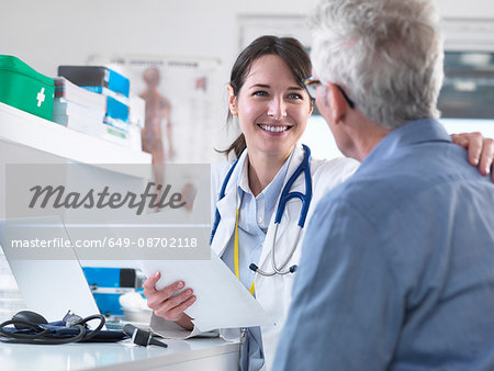 Doctor sharing good results with patient in clinic Doctor sharing good results with patient in clinic