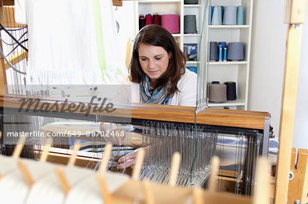 Young woman using loom