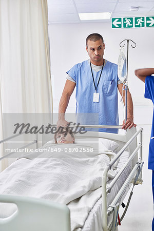 Nurse pushing patient in hospital bed