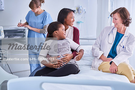 Girl patient and her mother talking to female doctor on hospital children's ward Girl patient and her mother talking to female doctor on hospital children's ward