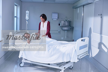 Girl patient in bed tended by her mother on hospital children's ward Girl patient in bed tended by her mother on hospital children's ward