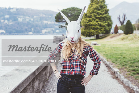 Portrait of woman wearing rabbit mask with hands on hips, Lake Como, Italy