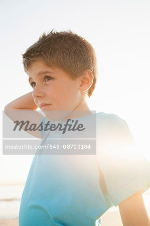 Boy with hand on head looking away