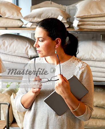 Mature female customer gazing at cushions in gift shop