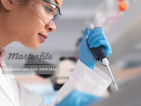 Scientist pipetting a sample into a phial during an experiment in a laboratory