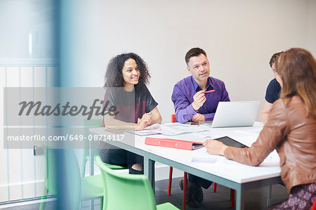 Designers having meeting at design studio boardroom table