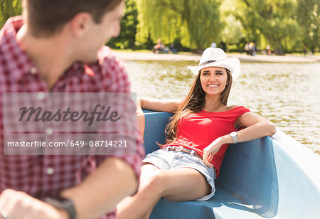 Happy young couple rowing on boating lake in Regents Park, London, UK