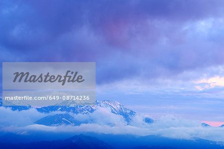 Mist and snow capped mountains at dawn,  Bolshoy Thach (Big Thach) Nature Park, Caucasian Mountains, Republic of Adygea, Russia