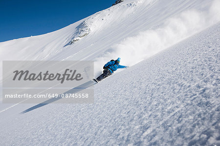 Male snowboarder speeding down steep mountain, Trient, Swiss Alps, Switzerland