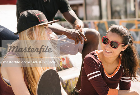 Two female friends chatting in city skatepark Two female friends chatting in city skatepark