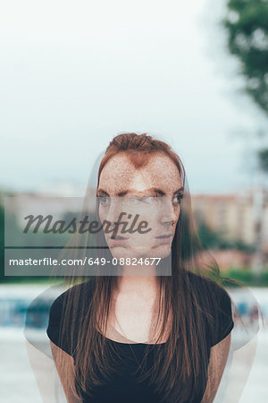 Double exposure portrait of young woman with freckles and long red hair