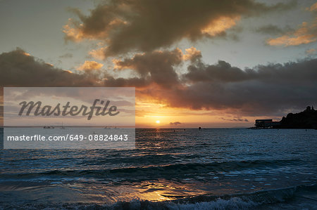 Silhouette of boats on sea at sunrise, Tenby, Pembrokeshire, Wales