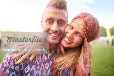 Two friends at festival, covered in colourful powder paint