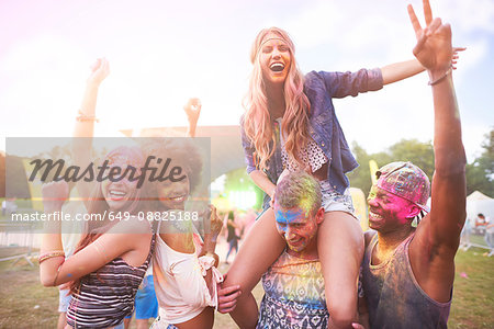 Portrait of group of friends at festival, covered in colourful powder paint