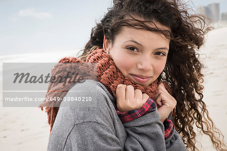 Portrait of young woman wrapped in scarf on windy beach, Western Cape, South Africa