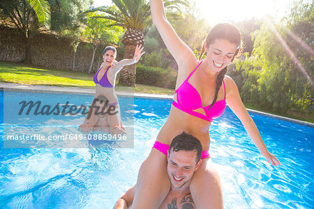 Friends fooling around in swimming pool