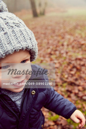 Male toddler in knitted hat in forest