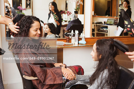 Girl and mother holding hands while having their hair styled in hair salon - Stock Photo - Masterfile - Premium Royalty-Free, Code: 649-08901367 Girl and mother holding hands while having their hair styled in hair salon - Stock Photo - Masterfile - Premium Royalty-Free, Code: 649-08901367