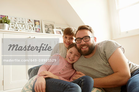 Portrait of mid adult man with son and daughter reclining on beanbag chair