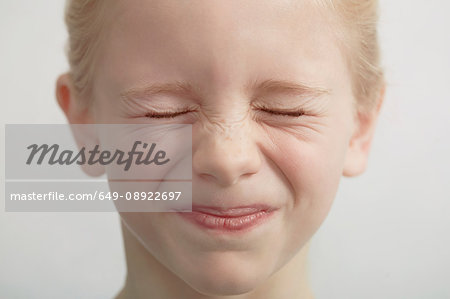 Portrait of young girl eyes closed tightly close up Stock