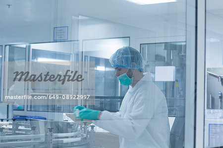 Worker packaging products in pharmaceutical plant