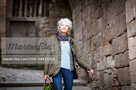 Woman walking in rural street, Bruniquel, France